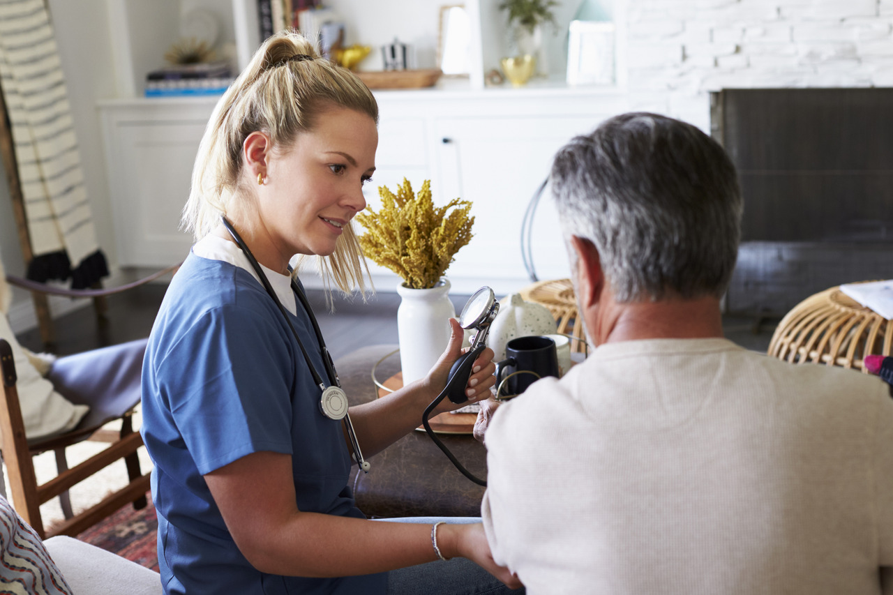 female healthcare worker measuring the blood pressure of senior man during a home visit 