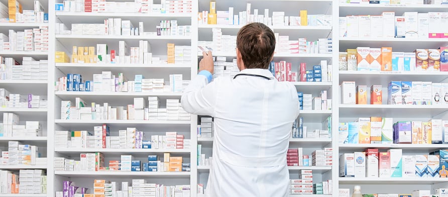 A pharmacist pulls a product down off of a shelf