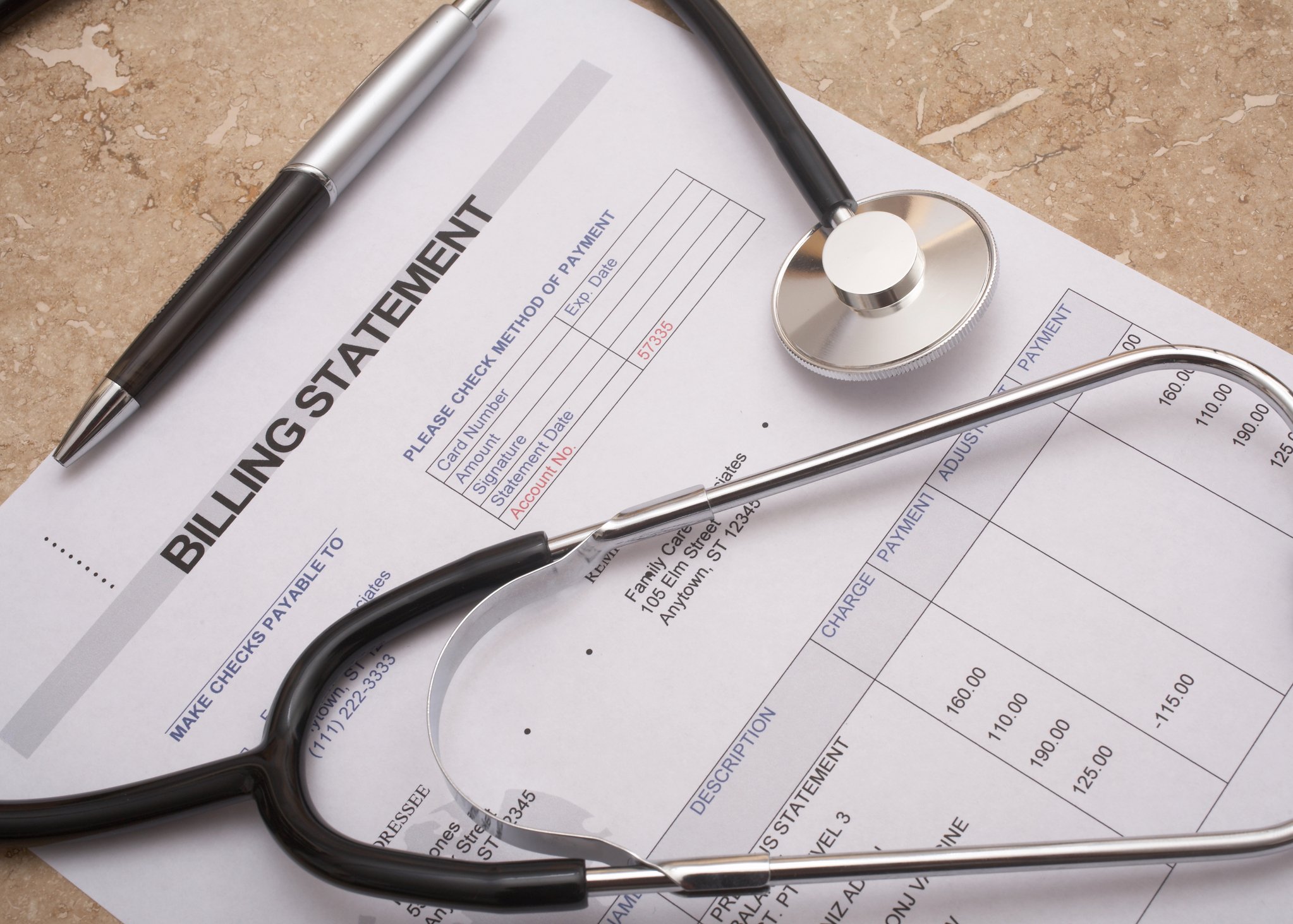 A medical bill with a stethoscope and pen sitting on top