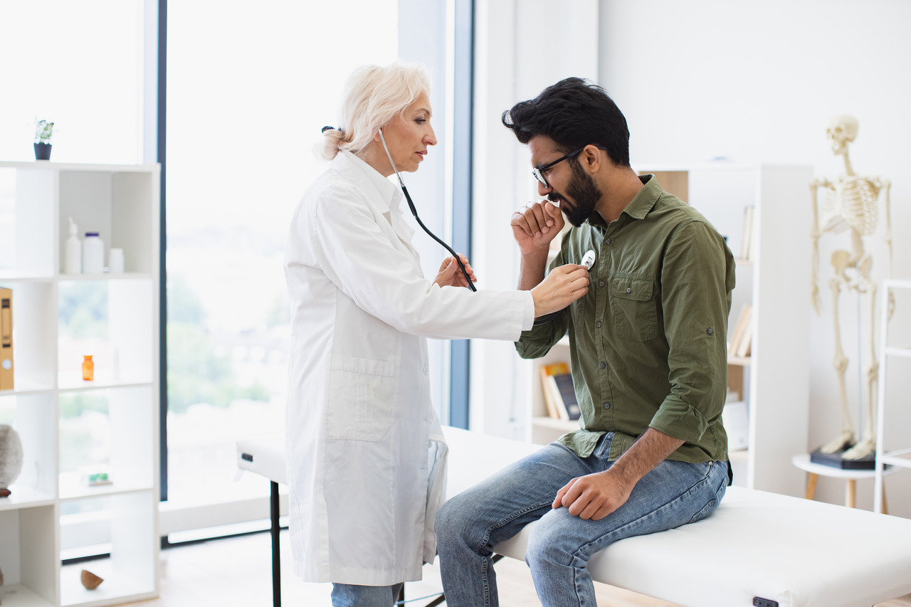 female doctor performs clinical exam on male patient